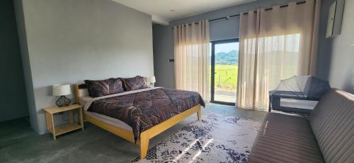 a bedroom with a bed and a large window at The Zain's Pool Villa for 4 pax, Langkawi in Ulu Melaka