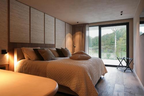 a bedroom with a bed and a large window at Tarida Durbuy in Durbuy