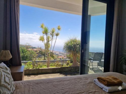 a bedroom with a bed and a view of the ocean at CoLiving Funchal in Funchal