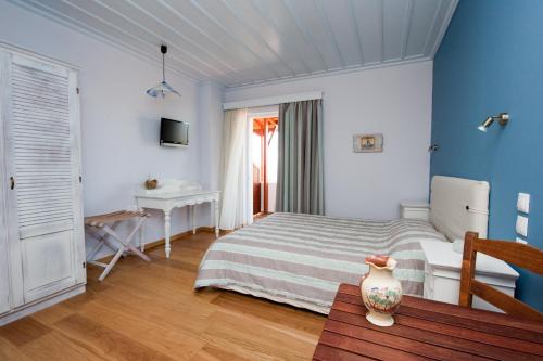 a bedroom with a bed and a desk and a table at Zorbas Apartments in Volissos