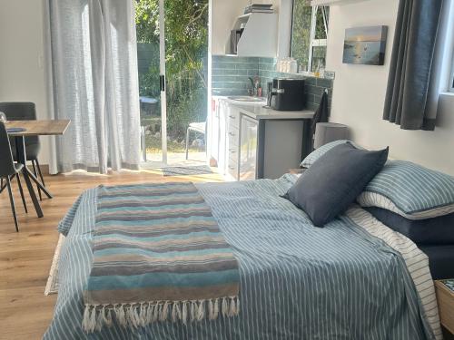 a bedroom with a bed and a kitchen with a window at Dove Cottage in Oakdale