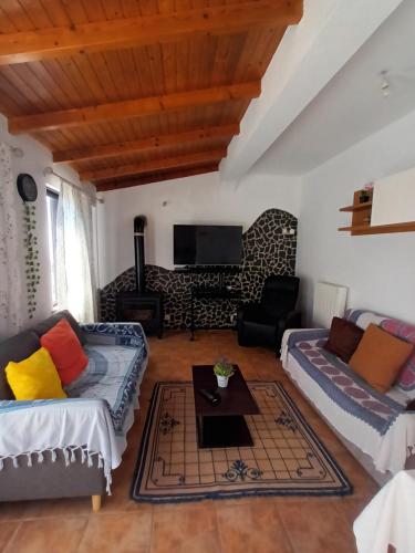 a living room with two couches and a tv at Casa marreiros in Aljezur