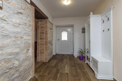 a hallway with a stone wall and a white door at Casa Mia By Kompas Villas in Butkovići