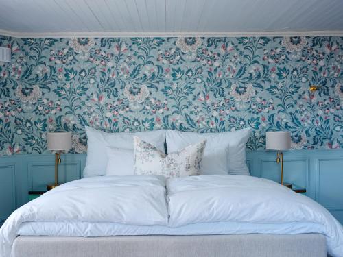 a bedroom with a large bed with a floral wallpaper at Nusfjord Village & Resort in Nussfjord