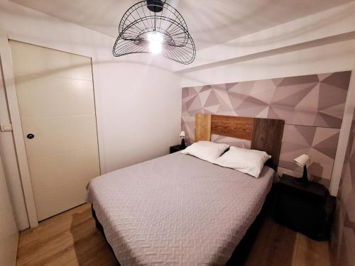 a bedroom with a bed and a chandelier at Le patio Mézois in Mèze