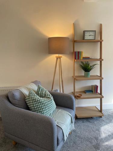 a living room with a couch and a lamp at Martindales Yard in Kendal