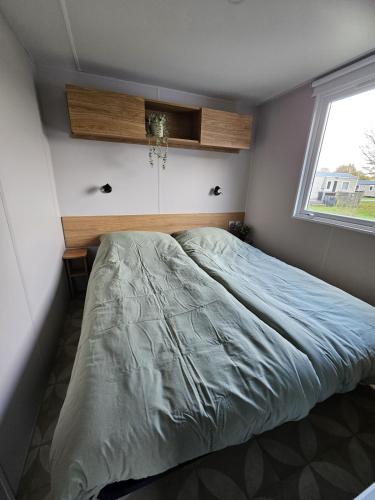 a bedroom with a large bed with a window at Eekhoorn 7 in Gasselte