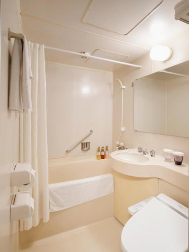 a white bathroom with a sink and a toilet at Hotel Sunroute Taipei in Taipei