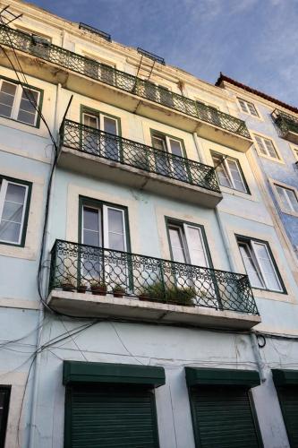a white building with a balcony and windows at Aurea Stay Lisbon-Quarto privado no centro in Lisbon
