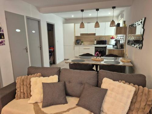 a living room with a couch and a kitchen at Chez Isa, Les pieds dans l'eau in Valras-Plage