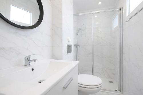 a white bathroom with a toilet and a shower at Aurea Stay Lisbon-Quarto privado no centro in Lisbon
