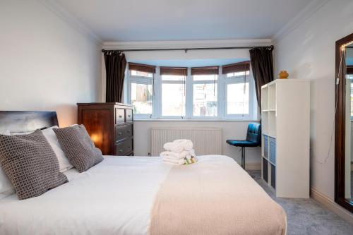a bedroom with a white bed with a stuffed animal on it at Spacious 4Bed Home with Decked Garden Forest Hill - Pass the Keys in London