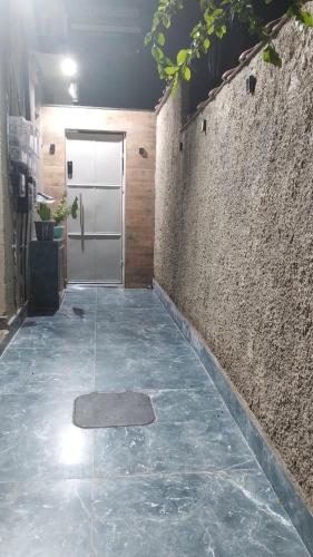 a hallway with a door and a stone wall at Loft Moderno 1 in Volta Redonda
