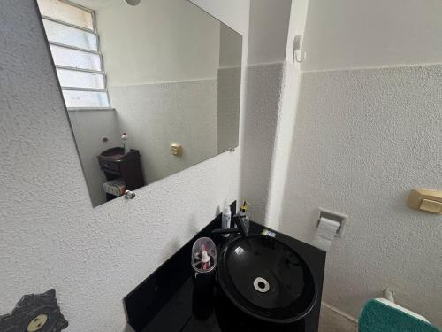 a bathroom with a black sink and a mirror at Apartamento alto de Teresópolis in Teresópolis