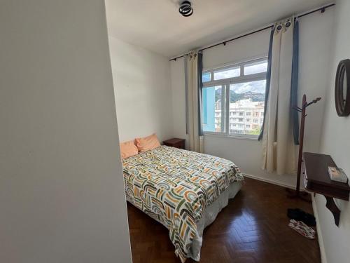 a small bedroom with a bed and a window at Apartamento alto de Teresópolis in Teresópolis