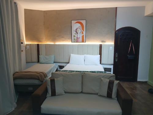 a living room with a couch and two beds at Aconchego - Centro in Miguel Pereira