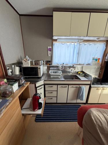 a small kitchen with a sink and a microwave at Hermit 知床 in Shari