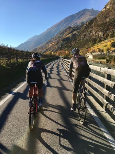 two people riding their bikes down a road at Klostergut in Castelbello-ciardes