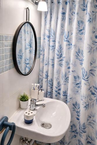 a bathroom with a sink and a blue and white shower curtain at Casa rural "Garnacha de Borja" guest home in Borja