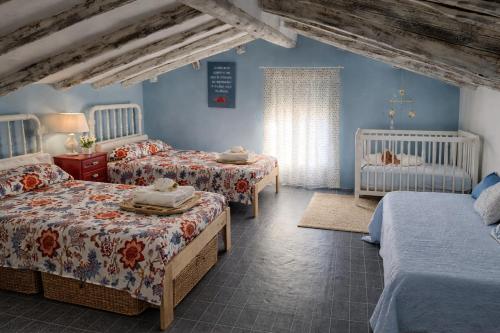 a bedroom with three beds and two babies at Casa rural "Garnacha de Borja" guest home in Borja