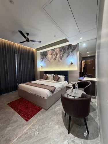 a bedroom with a bed and a table and chairs at Hotel Eastleigh in Ludhiana