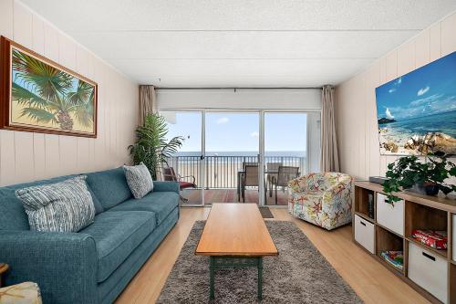 a living room with a blue couch and a table at El Capitan 206 - Dolphin Watch in Ocean City