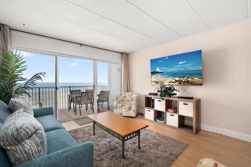a living room with a blue couch and a table at El Capitan 206 - Dolphin Watch in Ocean City