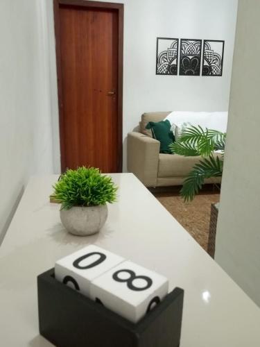 a white table with a plant on top of it at Refúgio Charmoso 1 in Volta Redonda