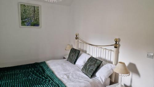a bedroom with a bed and a picture on the wall at Rose Cottage Solway Self Catering in Cardurnock