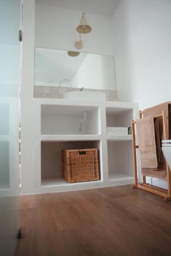 a bathroom with a sink and a basket on the floor at OKTO Beach Loft in Praia do Almoxarife