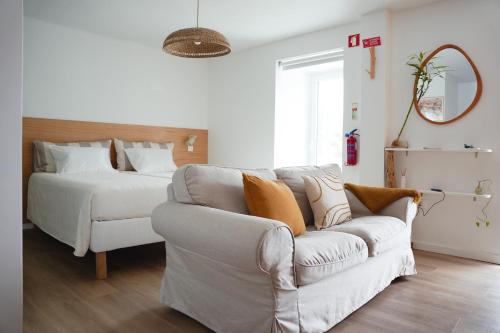 a living room with a couch and a bed at OKTO Beach Loft in Praia do Almoxarife
