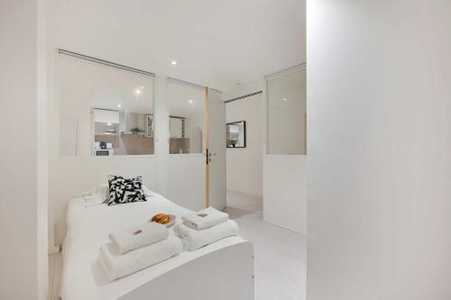a white room with a white couch and towels at Spacious apartment-2BR-4P in Le Kremlin-Bicêtre