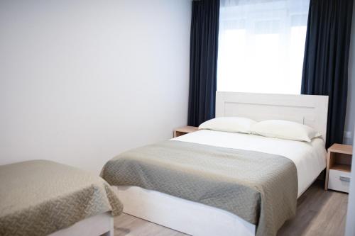 a bedroom with two beds and a window at Dzūkija Hotel in Alytus