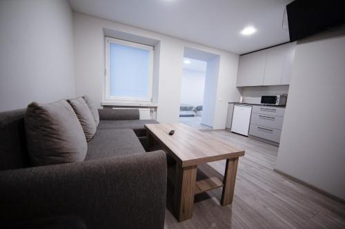 a living room with a couch and a wooden table at Dzūkija Hotel in Alytus