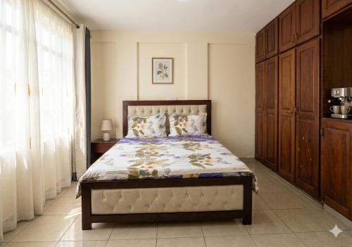 a bedroom with a bed and a large window at 2 chambres residence Dovv quartier Odja in Yaoundé