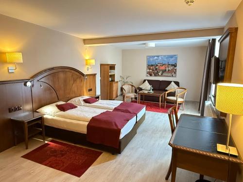a bedroom with a bed and a living room at Burghotel Nürnberg in Nuremberg