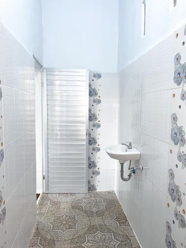 a white bathroom with a sink and a shower at Nerly's Panorama in Bukit Lawang