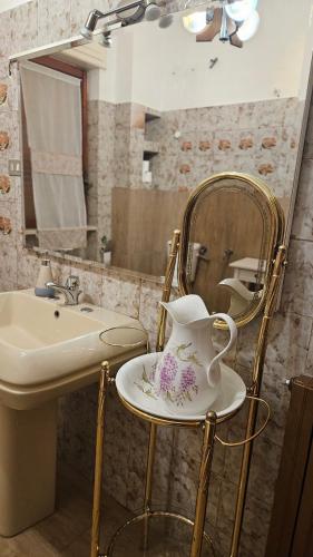 a bathroom with a sink and a chair with a cup on it at Adri's House in Monterotondo