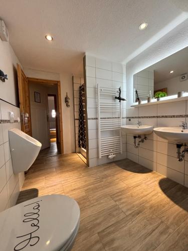 a bathroom with two sinks and a toilet at Ferienwohnung Elbbrise in Riesa