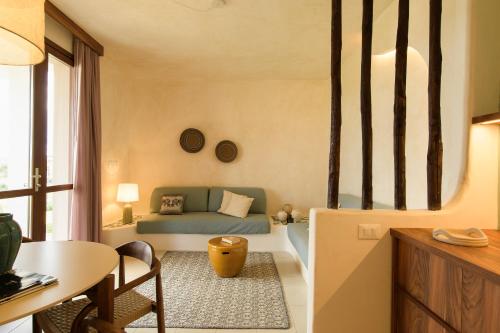 a living room with a couch and a table at Hotel Baia Tartuga in Stintino