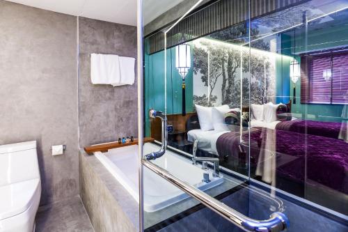 a bathroom with two beds and a shower at Lao Poet Hotel in Vientiane