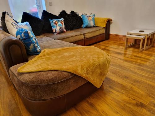 a living room with a couch with a yellow blanket on it at Seagulls Nest Holiday Cottage in Blackpool