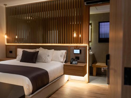 a hotel room with a bed and a telephone at Punto Suites Periférico Sur in Mexico City