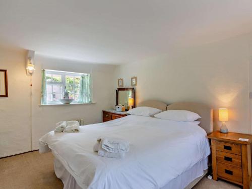 a bedroom with a large white bed and a window at 2 Bed in Bridport oc-77557 in Loders