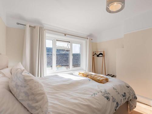 a bedroom with a white bed with a window at 3 Bed in Swanage oc-84019 in Swanage