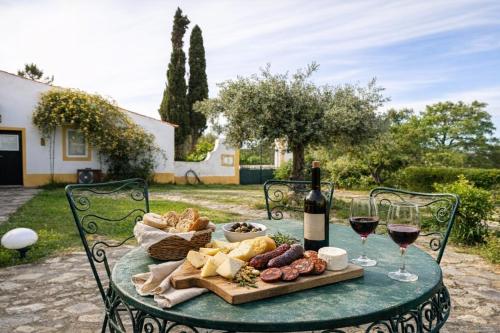 a table with a plate of food and glasses of wine at Monte Machial Private Villa, Pool & Event Space in Alvega