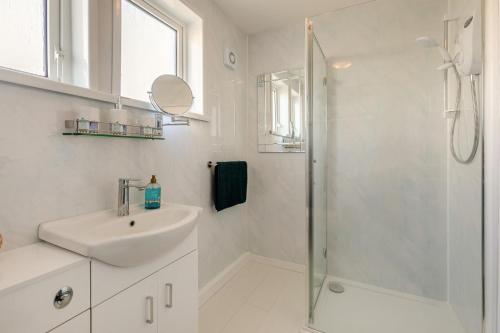 a white bathroom with a sink and a shower at 2 Bed in Mullion oc-k7968 in Mullion
