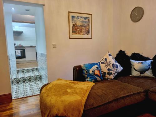a living room with a couch with pillows on it at Seagulls Nest Holiday Cottage in Blackpool