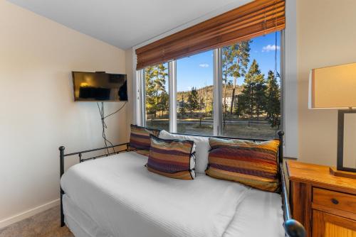 a bedroom with a bed and a large window at Pines #2165 in Keystone