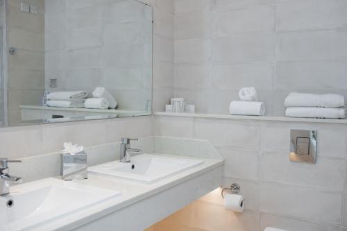 a white bathroom with two sinks and a mirror at Killeen House Hotel in Killarney